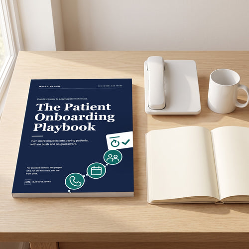 The Patient Onboarding Playbook on a desk beside a phone and an open notebook